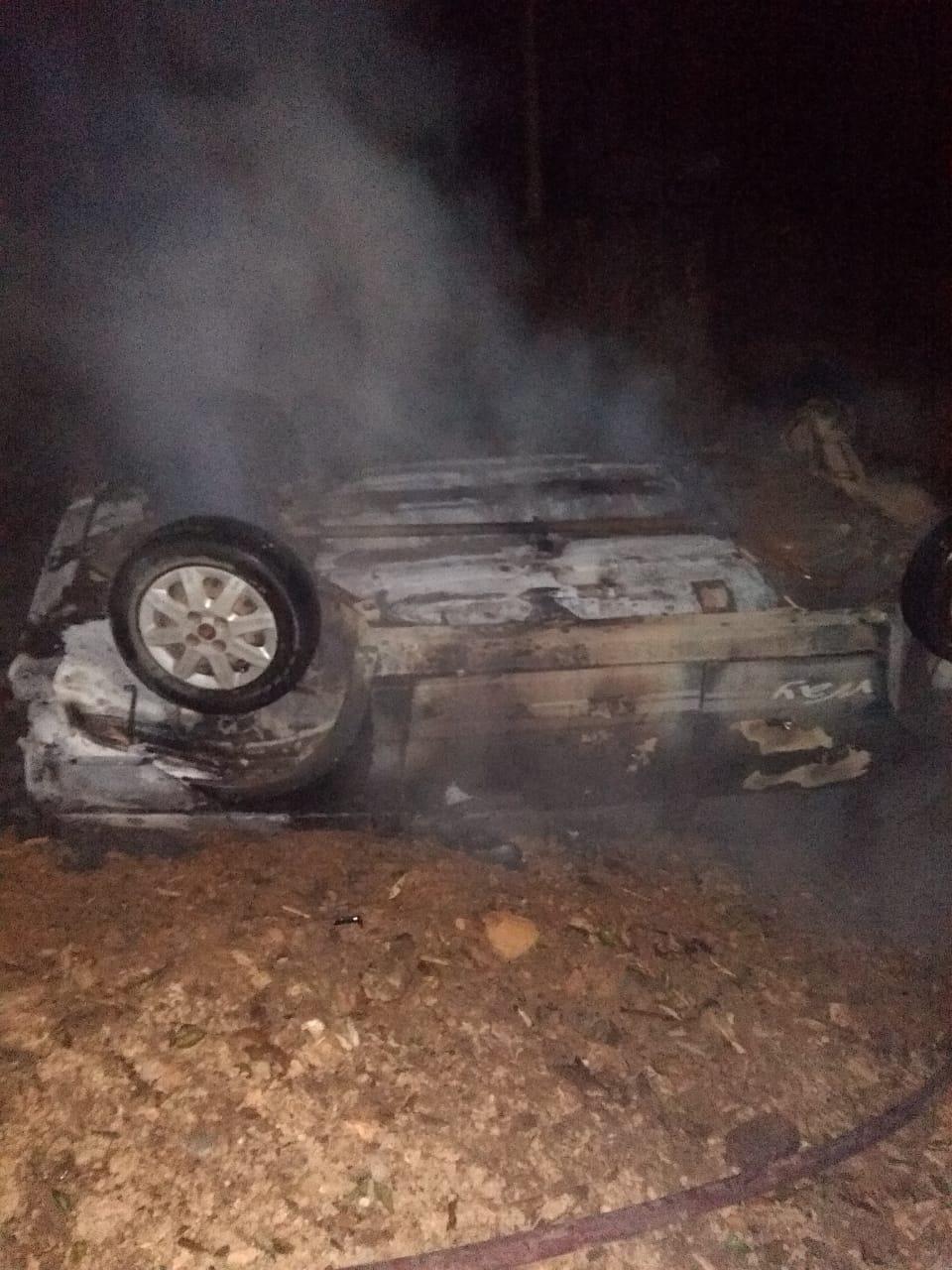 Veículo pega fogo após sair da pista e capotar